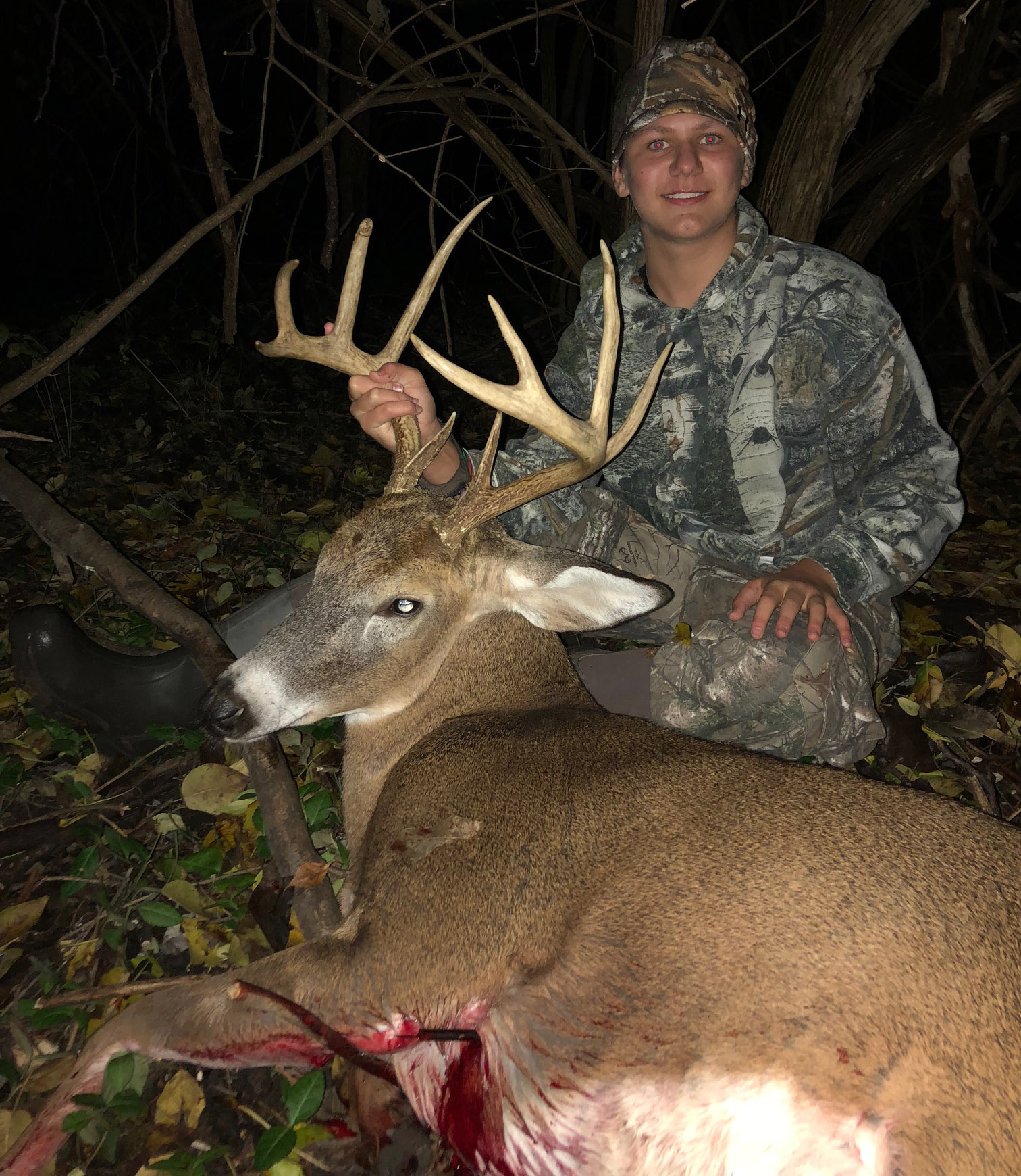 boy posing with buck