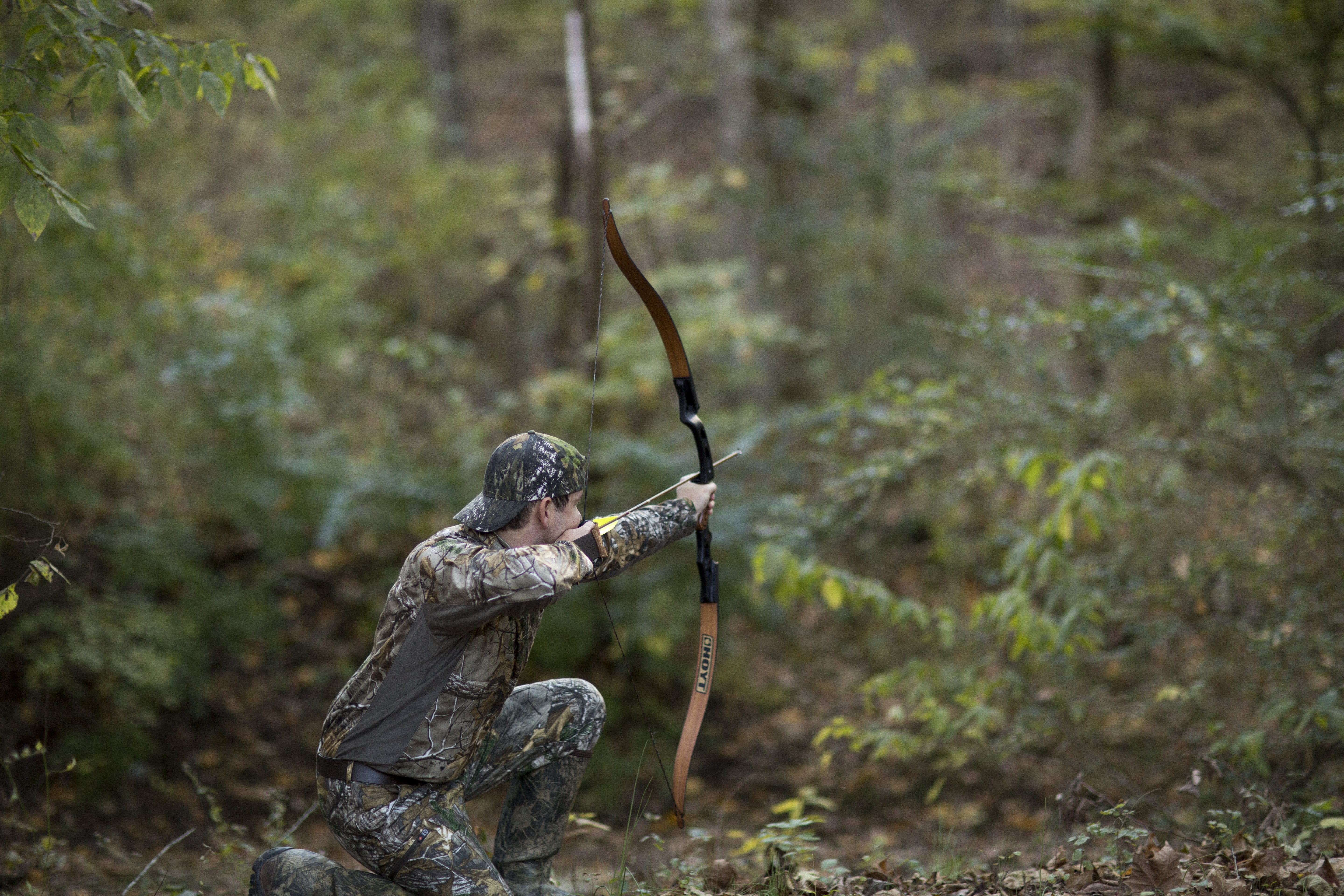 archer shooting arrow in the woods