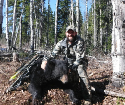 hunter posing with black bear