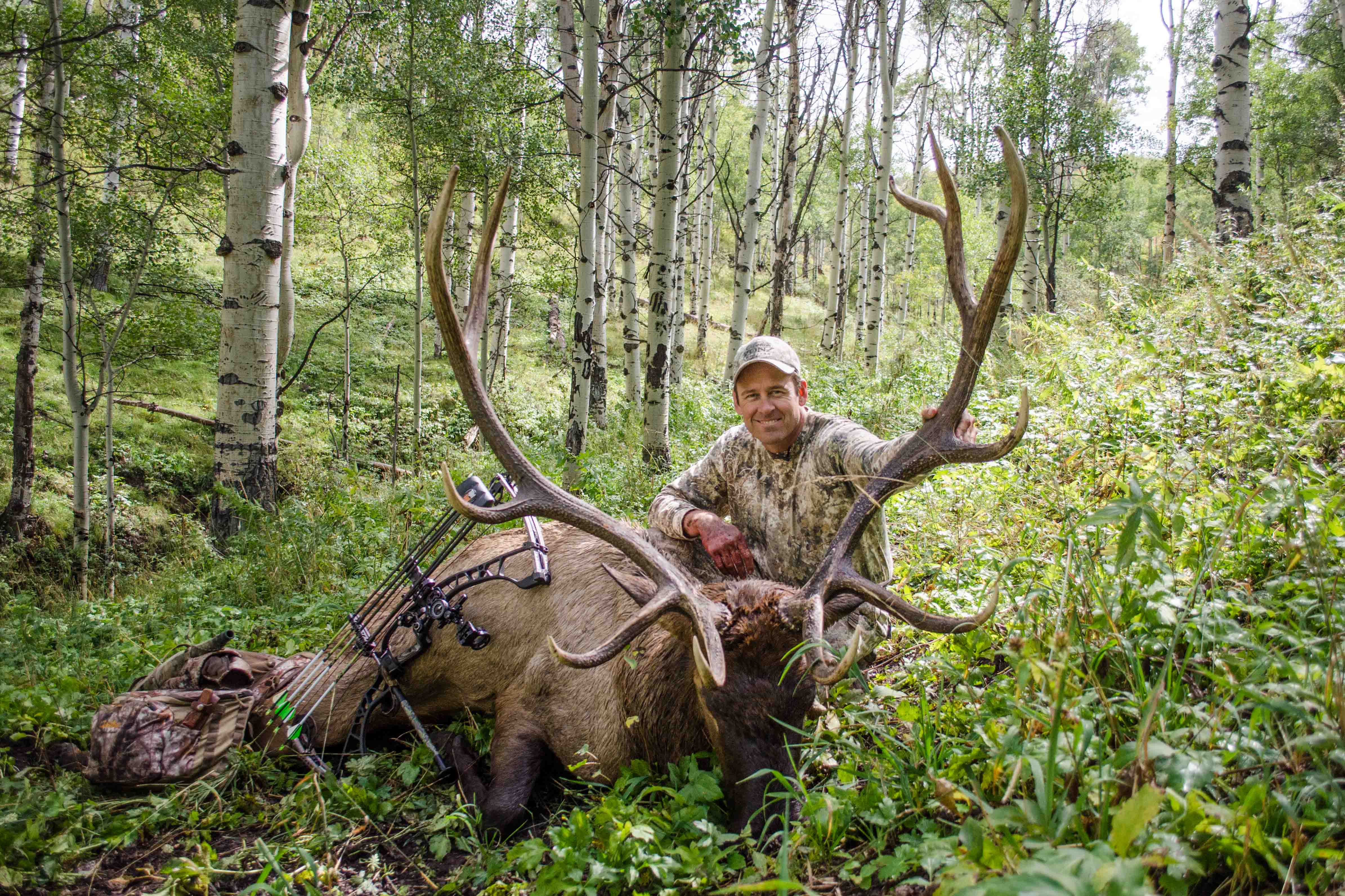 man posing with downed elk