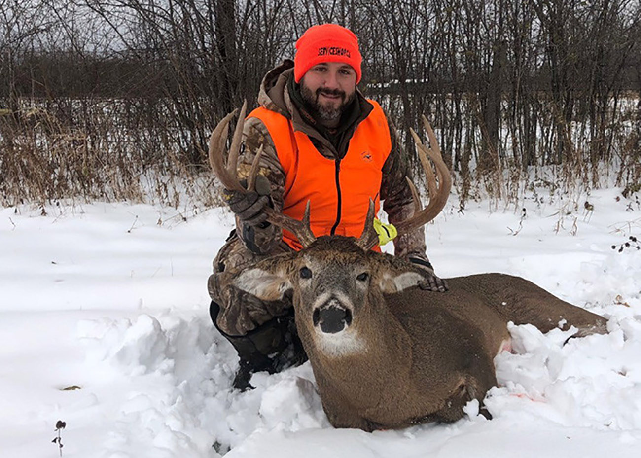 hunter posing with buck