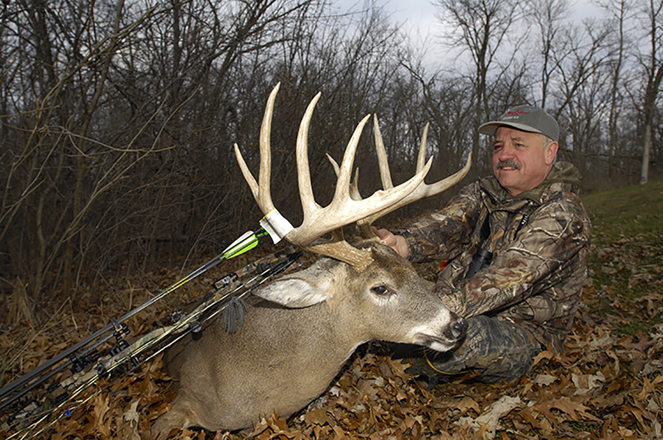 man posing with buck